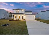 Charming two-story home with a well-manicured lawn and attached two-car garage, complemented by a beautiful twilight sky at 265 Lucca Dr, Summerville, SC 29486