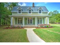 Charming two-story home with a metal roof, inviting front porch, and well-manicured lawn at 345 Mentor Rd, Summerville, SC 29483