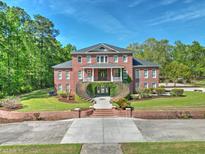 Elegant brick home featuring symmetrical design, manicured lawn, and beautiful landscaping at 349 Mentor Rd, Summerville, SC 29483