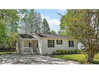Charming single-story home with a covered porch, black shutters, and a driveway at 63 Guerry Cir, Goose Creek, SC 29445