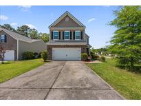 Inviting two-story home with a brick-accented facade, well-maintained landscaping, and a spacious driveway at 9652 Spencer Woods Rd, Ladson, SC 29456