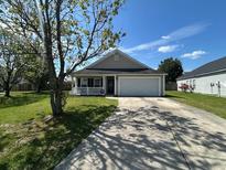 Charming single-story home with a well-maintained lawn and a two car garage at 1119 Moss Grove Dr, Moncks Corner, SC 29461