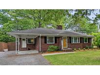 Charming brick home featuring a covered carport, landscaped front yard, and a welcoming yellow front door at 1211 Eastwood Ave, Hanahan, SC 29410