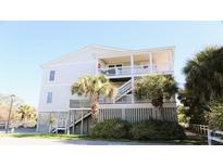 Coastal home exterior with palm trees and covered decks offering outdoor living spaces at 126 Jungle Rd # 7B, Edisto Beach, SC 29438