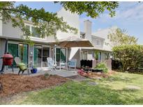 An inviting outdoor patio includes a charcoal grill, chairs, and garden beds, perfect for entertaining and relaxation at 1307 Ventura Pl, Mount Pleasant, SC 29464