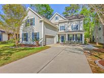 Charming two-story home with gray siding, blue shutters, landscaped yard and a welcoming front porch at 134 Comiskey Park Cir, Summerville, SC 29485