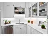 Bright kitchen features white cabinetry, subway tile backsplash, stainless steel appliances, and quartz countertops at 139 Tradd St # 2, Charleston, SC 29401