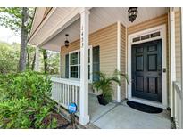 Charming home featuring a cozy front porch and black front door at 1453 Joy Ave, Charleston, SC 29407