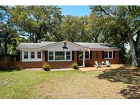 Charming brick home with a cozy front porch and lush trees, perfect for a relaxing coastal lifestyle at 17 24Th Ave, Isle of Palms, SC 29451