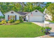 Charming single-story home with a well-manicured lawn and beautiful landscaping, showcasing its inviting curb appeal at 1722 S Nicole Pl, Charleston, SC 29414