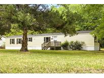 Single Gathering home with a well-maintained lawn, and a mature tree in the front yard at 177 Cady Dr, Summerville, SC 29483