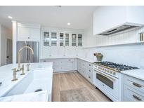 Bright, modern kitchen with marble countertops, stainless steel refrigerator, and hardwood floors at 2013 Grey Marsh Rd, Mount Pleasant, SC 29466