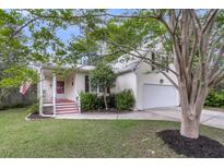 Charming home featuring a well-maintained lawn, tidy landscaping, and an attached two-car garage at 227 Lipman St, Summerville, SC 29483