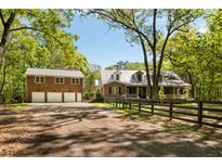 Charming brick home with three-car garage, complemented by a neatly fenced yard and mature trees at 5680 Dixie Plantation Rd, Hollywood, SC 29449