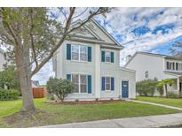 Charming two-story home with well-manicured lawn, mature tree, and blue shutters at 83 Creekside Dr, Summerville, SC 29485