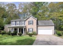 Charming two-story home with brick and siding, a well-manicured lawn, and a two-car garage at 9471 Netted Charm Ct, Ladson, SC 29456