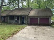 Charming single-story home featuring a brick facade, covered porch, and a two-car garage at 106 Glebe Rd, Summerville, SC 29485