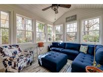 Bright sunroom features a cozy seating area with a blue sectional sofa and lots of natural light from multiple windows at 106 Sago Palm Ct, Summerville, SC 29483