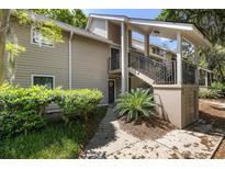 Attractive tan condominium complex with stairs to elevated porch and lush green landscaping at 108 High Hammock Villas Dr, Seabrook Island, SC 29455