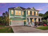 Charming two-story home featuring a covered porch, attached garage, and beautifully manicured landscaping at 123 Mcdonald Ct, Summerville, SC 29485
