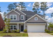 Charming home featuring a two-car garage, covered porch, and beautifully landscaped front yard at 153 Lucca Dr, Summerville, SC 29486