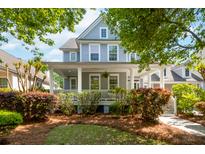Charming two-story home featuring a welcoming front porch with white columns and beautifully landscaped yard at 1977 Pierce St, Charleston, SC 29492