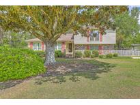 Charming two-story home with brick accents, red shutters, and a spacious landscaped front yard at 2042 Dogwood Rd, Charleston, SC 29414