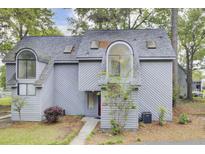Inviting gray townhouse with a unique arched window and well-maintained front lawn at 2159 Spoleto Ln # E, North Charleston, SC 29406