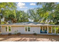 Charming coastal home featuring a shake shingle exterior, inviting front porch, and lovely mature landscaping at 248 Forest Trail, Isle of Palms, SC 29451