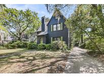 Charming exterior view of a two-story home with black siding and lush, mature landscaping at 27 Stocker Dr, Charleston, SC 29407