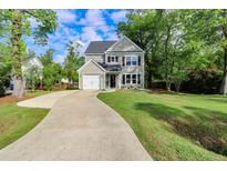 Charming two-story home with a well-manicured lawn and a long driveway leading to the attached garage at 3374 Dunwick Dr, Johns Island, SC 29455
