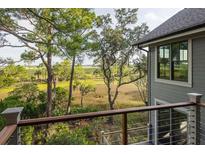 Relaxing balcony view overlooking lush marshlands and wooded area, perfect for enjoying nature at 37 Marsh Edge, Kiawah Island, SC 29455