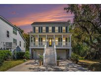 Charming two-story home features a spacious porch, light-colored siding, dark shutters, and well-manicured landscaping at 3717 Tip Ln, Mount Pleasant, SC 29466