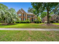 Beautiful two-story brick home featuring a well-manicured lawn and mature landscaping at 4407 Wild Thicket Ln, North Charleston, SC 29420
