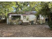Exterior shot of a home in disrepair with missing roof shingles and a leaf-covered yard at 5901 Sedgefield Dr, Hanahan, SC 29410