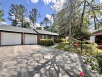Charming brick home with two-car garage, mature landscaping, and a long driveway at 1009 Highland Pines Rd, Ladson, SC 29456