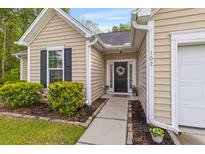 Inviting front entrance with a decorative wreath and landscaped garden beds leading to the front door at 102 Vango Dr, Goose Creek, SC 29445