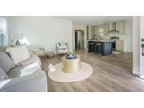 Open concept living area with an island kitchen, seating, and hardwood floors at 103 Bush Dr, Bonneau, SC 29431