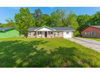 Charming single-story brick home featuring a well-maintained lawn, classic design, and mature trees at 1104 Margaret Dr, Ladson, SC 29456