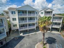 Three-story beach home featuring white picket balconies and elevated construction at 114 W Arctic Ave # B302, Folly Beach, SC 29439