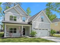 Charming two-story home featuring gray siding, a covered porch, and an attached two-car garage at 1325 Wannamaker Ave, Summerville, SC 29485