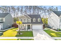 Charming two-story home with grey siding, a manicured lawn, and a welcoming front porch at 149 Caleb Ct, Ladson, SC 29456