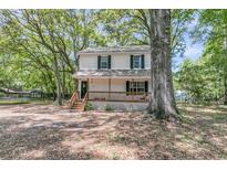 Charming two-story home with a welcoming front porch and lush, mature trees surrounding the property at 1628 Point Park Dr, Johns Island, SC 29455