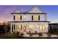 Elegant two-story white home with black shutters, a welcoming porch and a well-manicured lawn at 177 Cantona Dr, Summerville, SC 29483