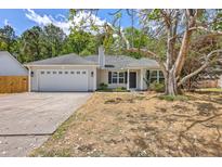 Charming single-story home with a well-manicured lawn, a two-car garage, and classic architectural details at 1932 Staffwood Rd, Johns Island, SC 29455