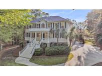 Stately two-story home with double porches and meticulous landscaping boasts a luxurious appeal at 2037 Shell Ring Cir, Mount Pleasant, SC 29466