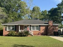 Charming brick home with well-manicured lawn, traditional windows, and quaint front porch perfect for relaxing at 210 Ellen St, Goose Creek, SC 29445