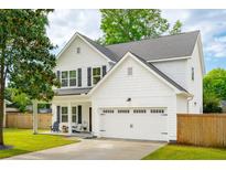 Charming two-story home featuring white siding, a well-manicured lawn, and an attached two-car garage at 217 7Th Ave, Mount Pleasant, SC 29464