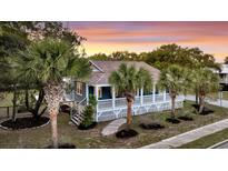 Charming home with a welcoming wrap-around porch and beautiful tropical landscaping at 2530 Jasper Blvd, Sullivans Island, SC 29482
