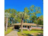Charming single-story brick home featuring a well-maintained lawn and mature palm trees at 26 Elmora Ave, Goose Creek, SC 29445